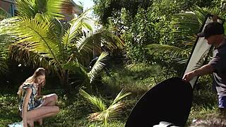 Сексуальная 18+ девчонка в шляпе и платье позирует голой на улице. Ее бритый тело блестит в закулисной съемке.