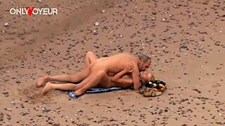 גבר מבוגר דופק מילף חמה קשה על חוף הים