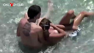 Amatorska para przyłapana na szybkim ruchaniu w falach oceanu na publicznej plaży.