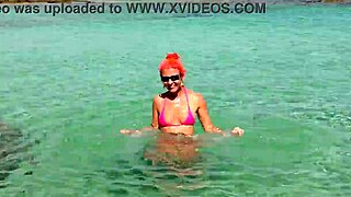 Pink bikini shining in a beautiful bay by the beach