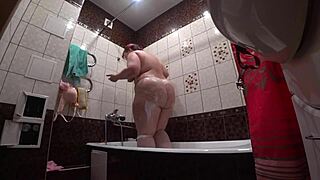 Behind the scenes a hidden camera spies on a fat porn model with big ass in bathroom