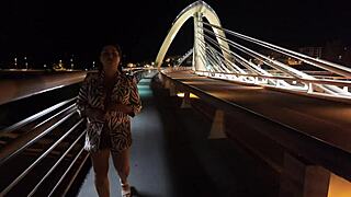 Luscious curvy MILF struts bridge flashing huge natural tits big ass no bra panties hairy pussy.