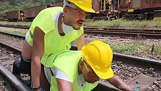 workers fix railway line with heavy labor as passive colleague bends over tracks in teaser